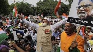 Indian protesters hold photographs of Indian Prime Minister Manmohan Singh as they shout slogans during an anti corruption protest near the Indian parliament in New Delhi, India, Sunday, Aug. 26, 2012