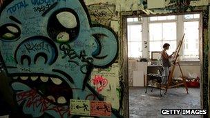 Arist painting a canvas inside the Tacheles