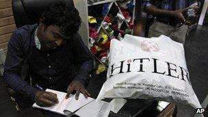 Rajesh Shah, one of the owners of the Hitler store, prepares a bill for a customer in Ahmadabad, India, Wednesday, Aug. 29, 2012.