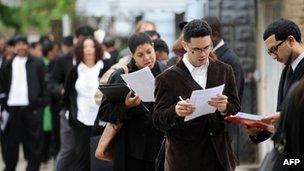 People seeking jobs wait in a line outside a job fair at a youth center to in Queens, New York on 3 May, 2012