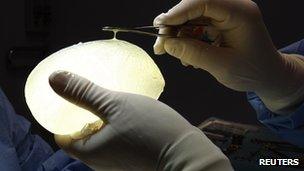 A surgeon holds a defective silicone PIP gel breast implant