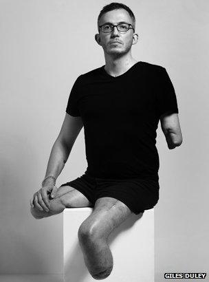 Giles Duley sitting on a plinth