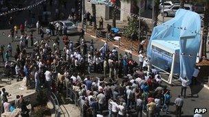 Crowds gather round a giant blue chair