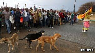 Striking mineworkers march outside Lonmin"s Marikana min