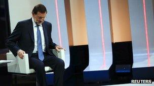 Spanish Prime Minister Mariano Rajoy sits on a chair to get ready for an interview on national Spanish public television