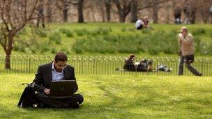 Man uses laptop in park