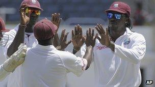 this image released by DigicelCricket.com, West Indies" Chris Gayle, right, celebrates with teammates at the end of the second inning on the third day of a second cricket Test match against New Zealand in Kingston, Jamaica, Saturday, Aug. 4, 2012. (