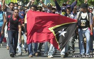 Men carry East Timor flag through Dili, 19 May 2002