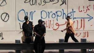 Egyptian soldiers stand guard in front of the US embassy, defaced by people protesting against an allegedly offensive film about the Prophet Muhammad, in Cairo, Egypt, on Wednesday