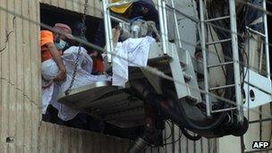 Pakistani rescuers remove a body from the garment factory