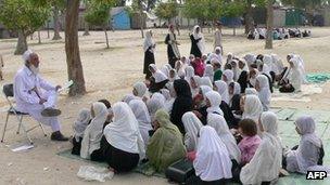 Schoolgirls study in an open air school in the outskirts of Jalalabad