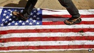 An Indian man walks over an American flag during a protest against the Innocence of Muslims film mocking the Prophet Muhammad in Hyderabad, India, on Friday