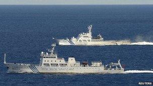 Chinese marine surveillance ship cruising with Japan Coast Guard ship in the background near the disputed islands on 14 September 2012