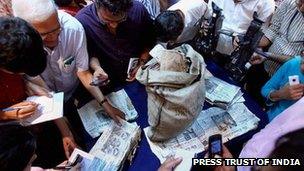 Journalists look at the newspapers taken out of the diplomatic bag