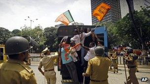 India"s main opposition Bharatiya Janata Party activists wave party flags as they are detained by police during a protest in Mumbai