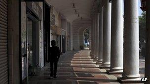 A man walks in a deserted market area during a strike in New Delhi