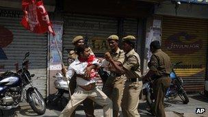 Indian police officers detain a left party activist during a nationwide strike in Hyderabad