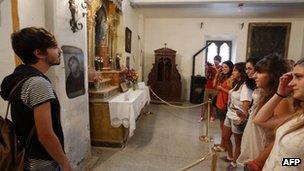 Visitors look at the fresco restored by Cecilia Gimenez