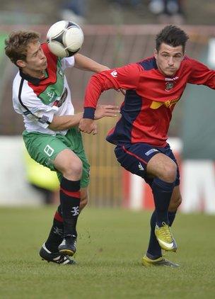 Glentoran's David Howland in action against Jordan Hughes of Lisburn Distillery