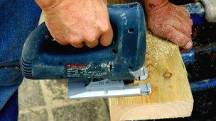 Carpenter sawing through wood