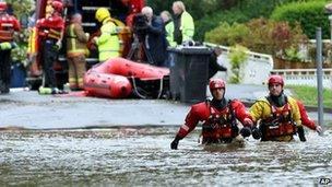 Rescue workers wade through flood water in Morpeth