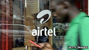 Man walks past mobile phone shop in Nairobi