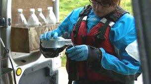 Environment Agency Wales employee taking water samples at Southerndown