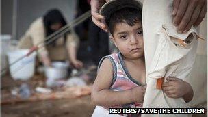 Khaled stands with his father at the Zaatari refugee camp in Jordan, in this Save the Children handout photo taken on August 30