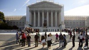 People wait outside the US Supreme Court in Washington, DC, 1 October 2012