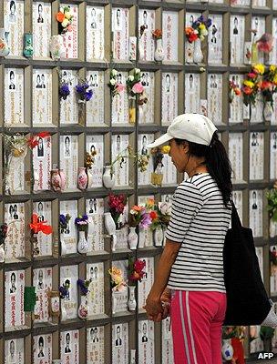 A woman prays at her ancestor's resting spot