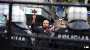 A Christian protester waves a cross outside a Belgrade gallery showing the gay-themed exhibition Ecce Homo, 3 October