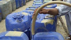 Man filling jerry cans with water