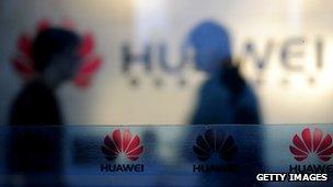 Staff and visitors walk pass the lobby at the Huawei office in Wuhan, central China