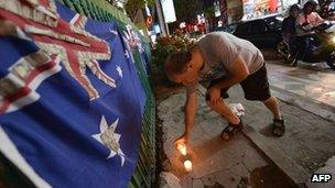 A tourist lights a candle at the Sari Club blast site on 10 October 2012