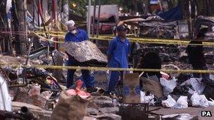 Men remove rubble from the scene on 16 October 2002