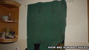 Kitchen window covered by a green blanket