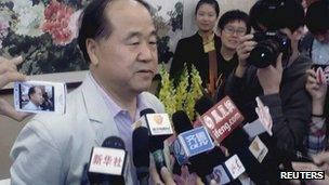 Chinese writer Mo Yan (L) talks to the press in his hometown Gaomi in China's Shandong province after he was notified with his Nobel prize for literature victory, 11 Oct 2012
