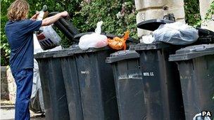 Man emptying rubbish into wheelie bin