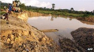 A boy sits beside the pit where miners died when the roof of an illegal gold mine collapsed at Dunkwa on-Offin in central Ghana (27 June 2010)