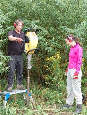 Dr McNamara (left) and Dr Rowe demonstrate how "Kevin", an adapted road-breaking, helps them collect soil samples