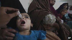 A Pakistani medic gives a polio vaccine to a child in Peshawar, Pakistan, Monday, Sept. 10, 2012