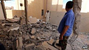 File pic: Libyan men inspect a destroyed building in Bani Walid on 11 October 2012