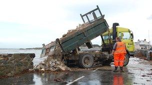 Rubble being tipped onto a coast road