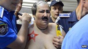 A Femen activist dressed as Belarusian President Alexander Lukashenko in Kiev