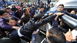 South Korean activists inside a truck scuffle with local residents as plainclothes police officers try to separate them following the launch of anti-North Korea leaflets across the border at a park in the border town of Paju on 29 October, 2012