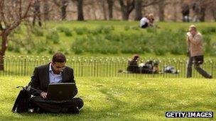 Man uses laptop in park