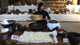 A woman demonstrating South Korean rice making technique