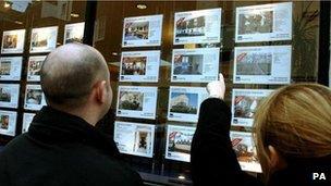 Couple looking in estate agent's window