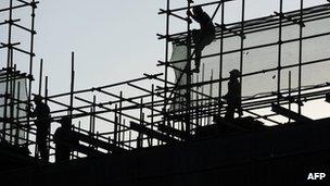 Workers erecting roof on building