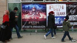 People walking past a film poster on Istanbul's Istiklal Avenue